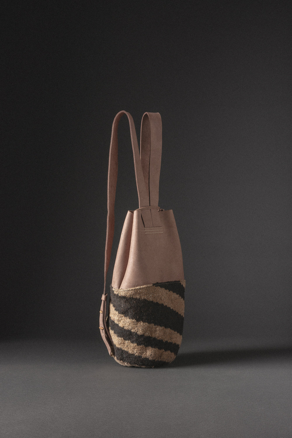 Mochila IWA en cuero y tejido arhuaco, diseño funcional y elegante para el día a día.