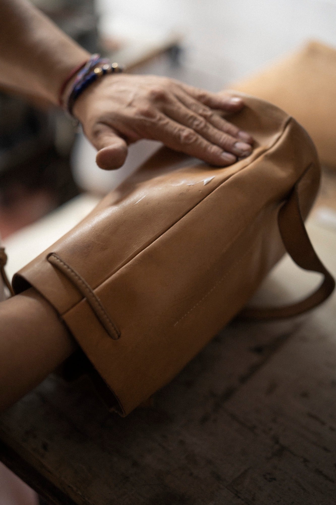 Una mano reposando sobre un bolso de cuero
